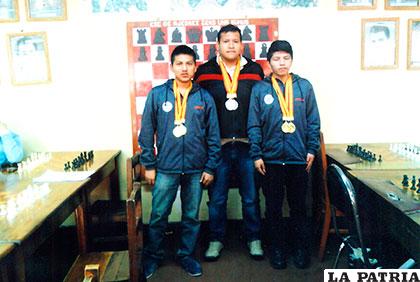 Sangüeza y Paniagua lucen sus medallas de oro junto al delegado de Oruro