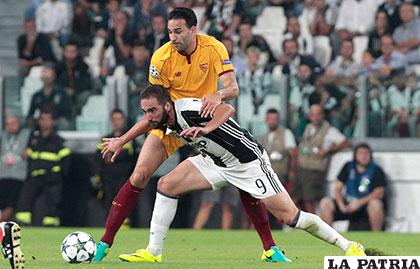 Juventus y Sevilla 0-0, Higuaín y Rami disputan el balón