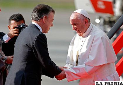 El presidente de Colombia, Juan Manuel Santos (izquierda), recibe al Papa Francisco en el aeropuerto de Bogotá