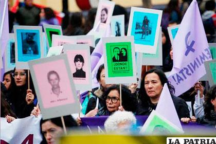 Manifestantes con pancartas durante la romería en memoria de las víctimas de la dictadura de Pinochet