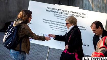 Una persona reparte papeletas en una campaña para referendo de independencia en Cataluña /abc.es