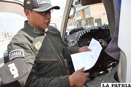 Un funcionario de Diprove muestra los documentos originales del vehículo