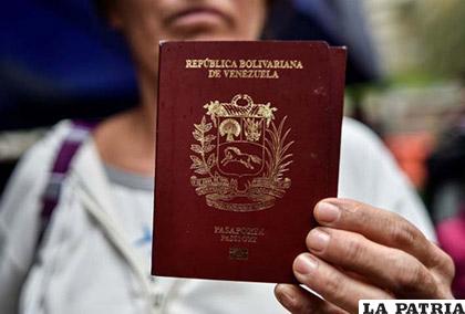 Una venezolana muestra su pasaporte tras cruzar de Ipiales en Colombia, a Tulcán en Ecuador /LaPatilla.com