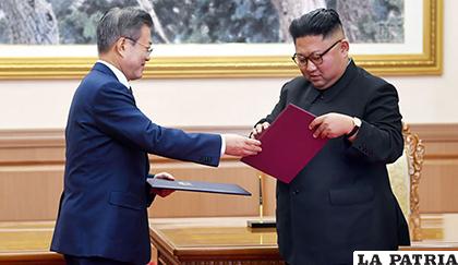 El líder norcoreano, Kim Jong-un (der.), y el presidente surcoreano, Moon Jae-in (i), intercambian documentos /TVN Noticias