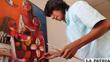 El pintor ecuatoriano Olmedo Quimbita hace una demostración de pintura durante una entrevista/ expreso.ec