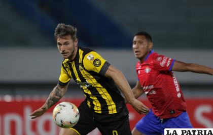 Matías Britos, con la pelota, le sigue de cerca Ronny Montero /APG
