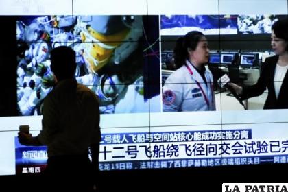 Noticiero de la televisora CCTV con un reporte sobre el regreso de astronautas chinos a la Tierra /AP Foto /Andy Wong