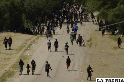 Migrantes haitianos caminan por un camino de tierra después de ingresar a Estados Unidos desde México /AP Foto /Eric Gay