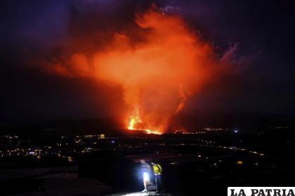 Dos personas caminan durante la noche mientras un volcán expulsa lava, en La Palma, Islas Canarias /AP Foto /Daniel Roca