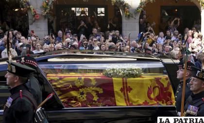 La gente observa el recorrido del cortejo fúnebre de la reina Isabel II del Palacio de Holyroodhouse a la Catedral de San Giles en Edimburgo /Andrew Milligan/Pool Photo vía AP
