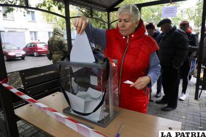 Una mujer deposita su voto durante un referéndum en una casilla electoral móvil 
/AP Foto
