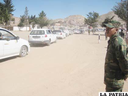 Un efectivo militar observa el paso de los vehículos