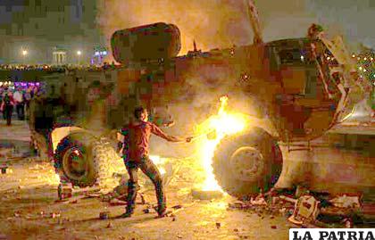 Un manifestante cristiano copto prende fuego a un vehículo del ejército durante choques con militares tras una manifestación en El Cairo