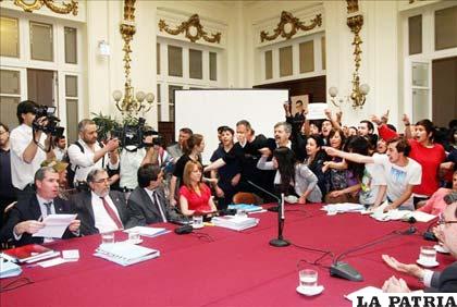 Manifestantes gritan consignas tras irrumpir en la comisión mixta del presupuesto para la educación que se celebra en el Ex congreso en Santiago (Chile)