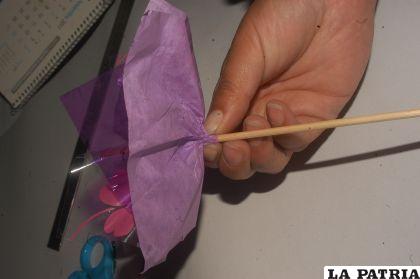 PASO 4
Formar la flor agarrando los papeles por el medio junto con el palito de brocheta y asegurar con el alambre limpiapipa