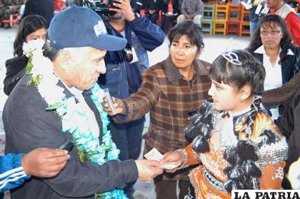 El ministro de Minería, José Pimentel, entrega el bono a una niña del colegio “Sebastián Pagador”