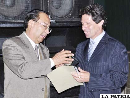 Juan Ortega, presidente de la Asociación de Docentes de la Facultad de Economía, entregó el reconocimiento a José Luis Bilbao (d), del hotel Edén