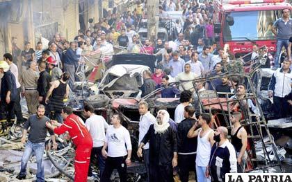 Varias personas observan los destrozos provocados por un coche bomba