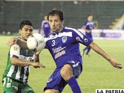 Ronald Rivero despeja el balón ante la mirada de Alcides Peña