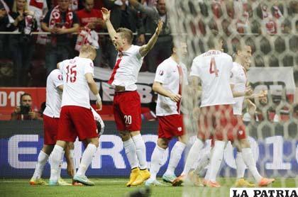 Arkadiusz Milik, derecha, festeja tras marcar un gol de Polonia 