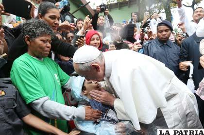 El Papa Francisco en medio de niños y personas humildes
