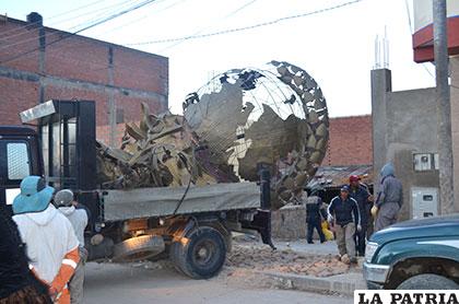 Escultura de un diablo sobre el globo terráqueo cayó por el viento