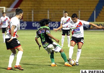 Eduardo Puña, en su afán de quitarle el balón a Darwin Lora /APG