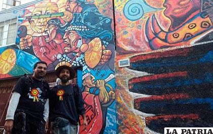 Dos muralistas posan delante de su obra /ANF