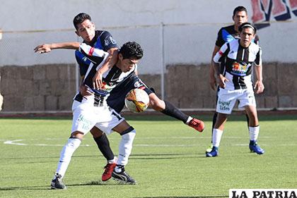 Amílcar Sánchez despeja el balón ante la arremetida de su rival