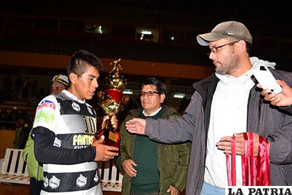 Raúl Reyes, presidente de la Asociación, entrega el trofeo de campeón a Andy Ledezma