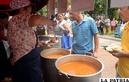Una mujer sirve comida tradicional que se encuentra a la venta hoy, en una plaza en Asunción /Cultura y Turismo
