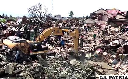 Un equipo de rescate usa una excavadora para buscar personas bajo las ruinas de una casa /TVN Noticias 