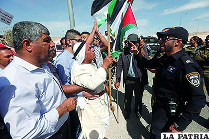 Manifestantes ondean banderas palestinas mientras protestan ante tropas de Israel contra el plan israelí /infoLibre