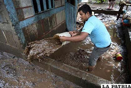 Un hombre saca agua de su casa inundada /EL INFORMADOR