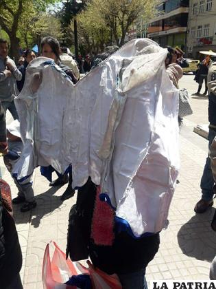 Padres muestran los trajes en malas condiciones fletados de los bordadores de la calle La Paz/ FACEBOOK