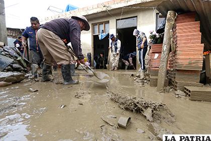 Obreros de la Alcaldía ayudan en la limpieza de las casas afectadas/ APG