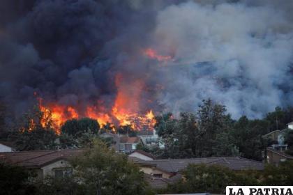 Las llamas del incendio consumen una ladera cerca de las casas en Chino Hills, California