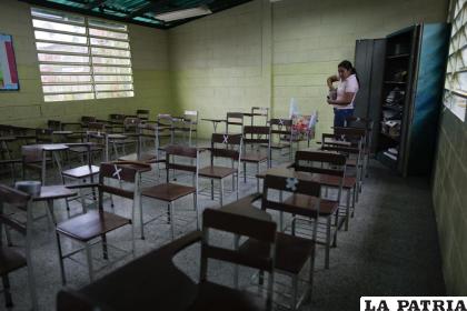 La maestra Margelis Delgado, de 36 años, prepara materiales escolares en un aula de la escuela Jerman Ubaldo Lira en Caracas /AP Foto /Ariana Cubillos