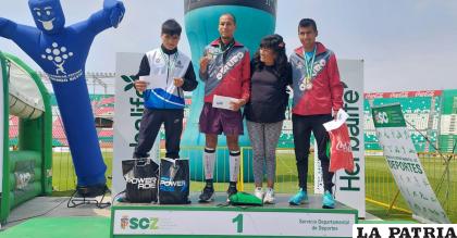 Los orureños Víctor Hugo Aguilar y Daniel Toroya en el podio junto a su entrenadora Nemia Coca /CPDST