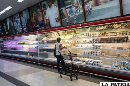 Fotografía de archivo en la que se registró a una compradora frente a las neveras, poco abastecidas, de un supermercado en Caracas (Venezuela) /EFE/Miguel Gutiérrez