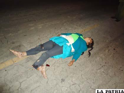 Una de las víctimas en medio de la carretera
