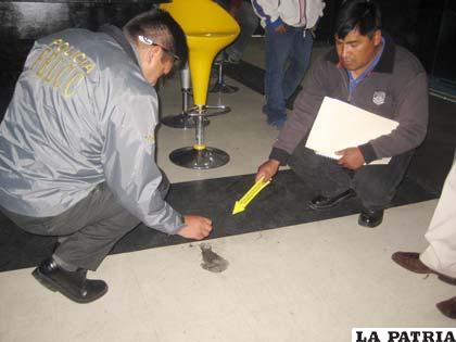 Los peritos de la Escena del Crimen de la Felcc, echan un reactivo al suelo para detectar la presencia de sangre