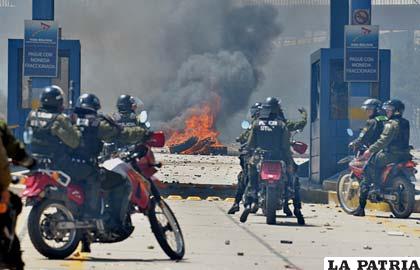 Efectivos policiales se retiran en motocicletas luego de los enfrentamientos con estudiantes de la UPEA