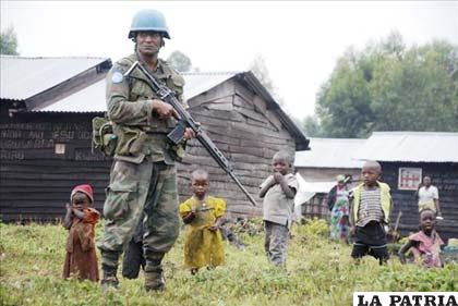 Soldado de la Monusco con un grupo de refugiados desplazados, cerca de la capital provincial de Goma, en el Congo