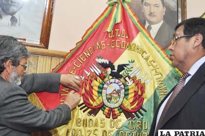 El rector de la UTO Rubén Medinaceli impone la condecoración en el estandarte de la Fcefa
