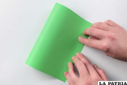 PASO 1
Corta una porción de cartulina verde de la medida que prefieras y dobla por la mitad.