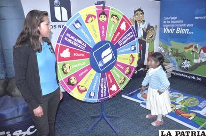 Niña participa del juego en stand de Impuestos Nacionales