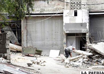 Un hombre busca entre los escombros en el campo de refugiados de Al Yarmuk, en el Sur de Damasco (Siria) /es.noticias.yahoo.com