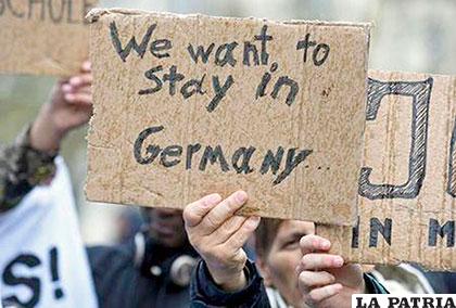 Un grupo de personas sostienen carteles durante una manifestación a favor de los refugiados en Hamburgo - Alemania /REUTERS