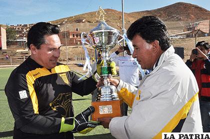 Vásquez hace la entrega del trofeo de campeón a Yapari